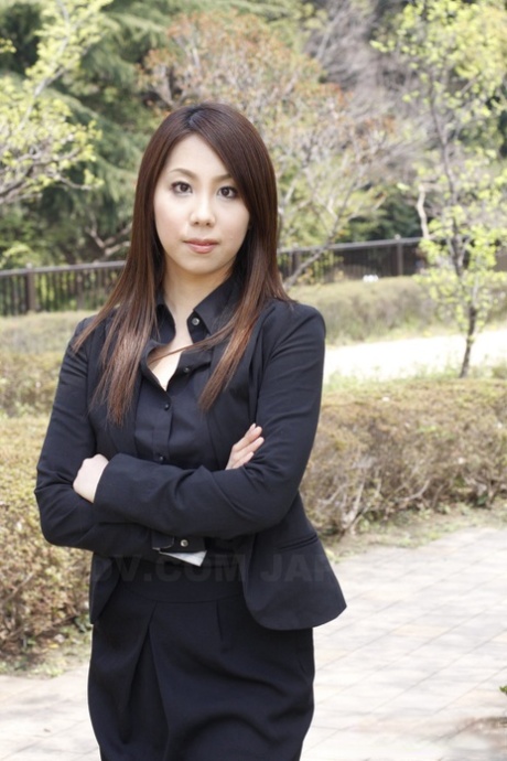 Das japanische Model Hikaru Matsu setzt ihre Brille in Business-Kleidung auf und ab