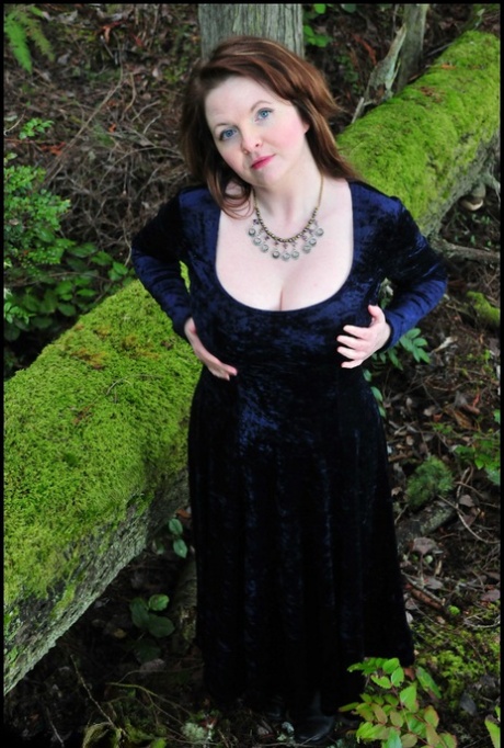 Mature woman Tasty Trixie heads into the woods to flash in a long velvet dress