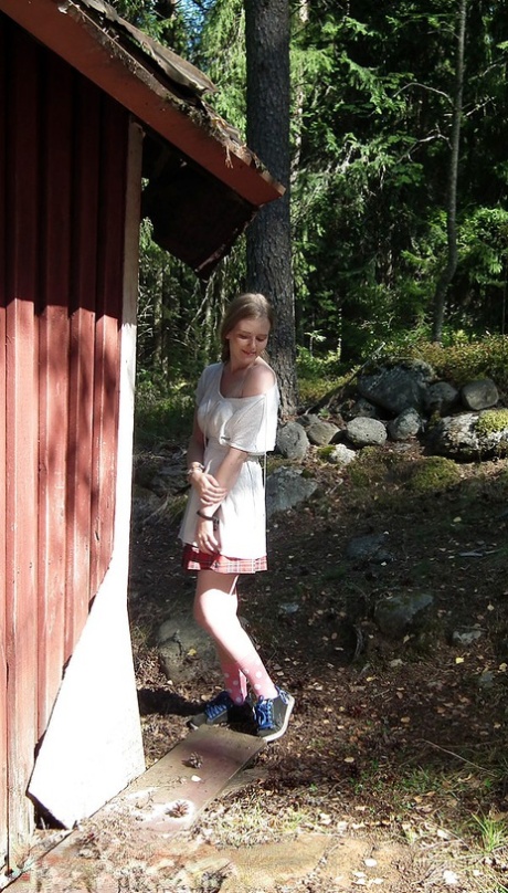 Una chica sola muestra sus tetas y su coño mientras fuerza la entrada en una cabaña abandonada