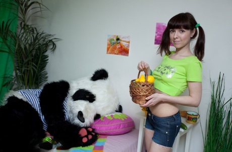 Young looking brunette Michele has sex with a panda on top of a bed in socks
