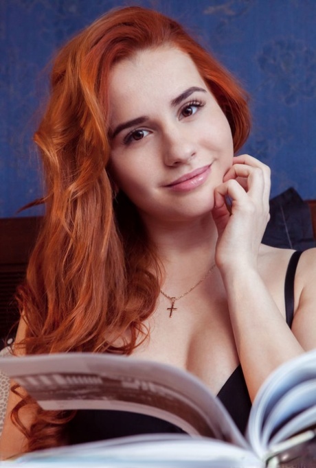 Den sexy rødhårede Nicole La Cray viser frem den trange spalten mens hun ligger naken på en seng.