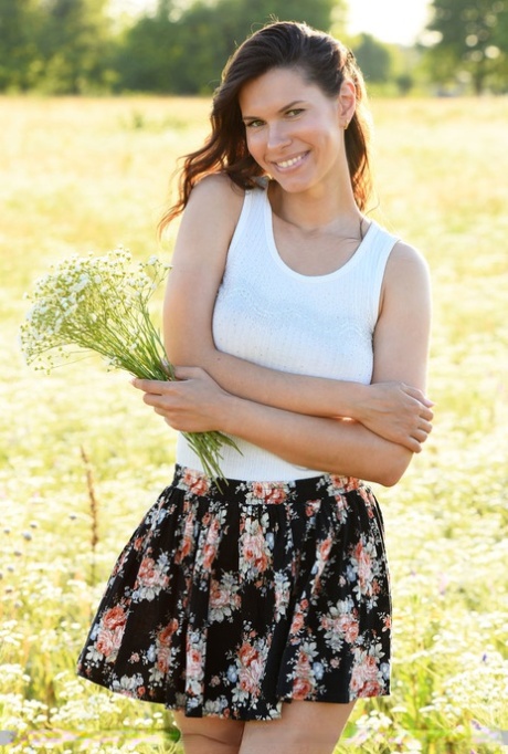 A jovem morena Suzanna A fica nua depois de se despir num campo de flores silvestres