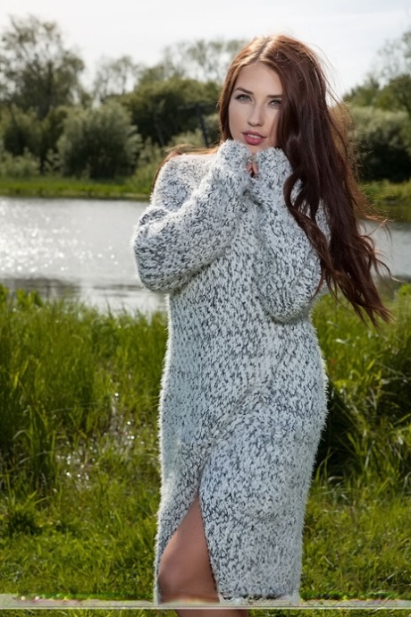 La bella teenager Niemira libera il suo grande corpo da un vestito di maglia in un campo