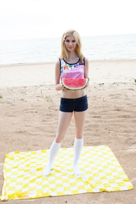 Blond nastolatka zdejmuje białe majtki i skarpetki przed pokazaniem swojej cipki na plaży