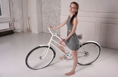 La joven belleza Lapa se baja de la bicicleta antes de modelar en cueros