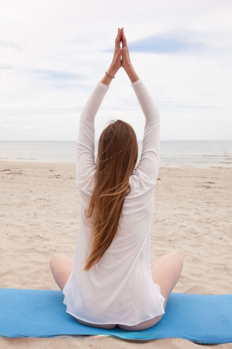 Den vita tonåringen Matilda Sun är naken när hon gör yoga på stranden