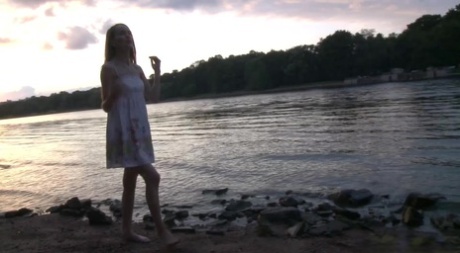 Une fille aux jambes nues relève sa robe pour aller faire pipi sur la plage.