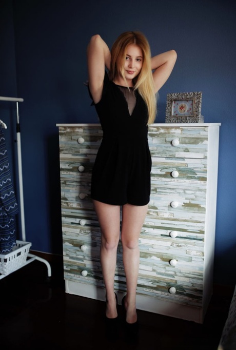 La joven pelirroja Molly Haze se quita un vestido negro antes de jugar con su coño en la cama