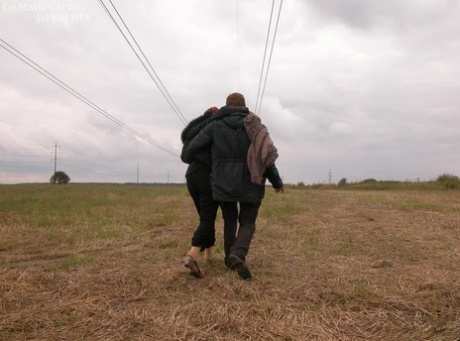 Older redhead fucks a homeless man on a blanket in a field