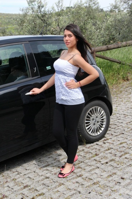Tmavovlasá žena osvobozuje své krásné nohy od balerín v autě