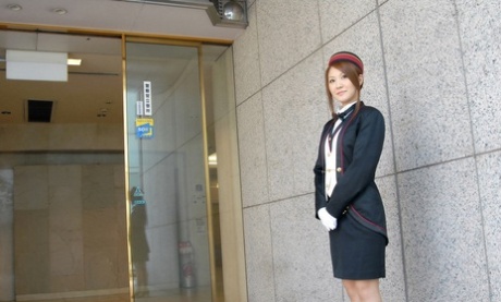Azafata japonesa pelirroja acaricia su gran cuerpo en una habitación de hotel