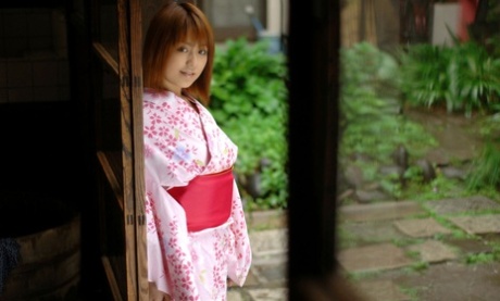 Die rothaarige japanische Teenagerin Nanami befreit ihre festen Titten und ihre Muschi von einem Bademantel