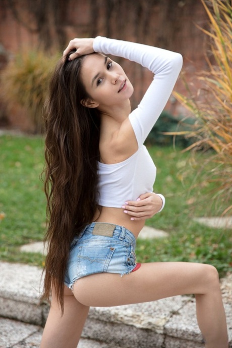 Langbeinige Teenagerin Leona Mia präsentiert ihre kahle Muschi auf Betonstufen
