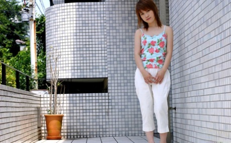 Het jonge Japanse meisje Akari toont verlegen haar harige poesje