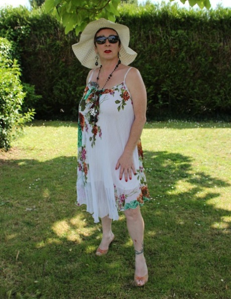 Mary Bitch, amateur mature, baisse son string sur une pelouse avec un chapeau de soleil