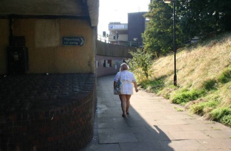 La enfermera mayor gorda Lexie Cummings se exhibe mientras camina por una acera