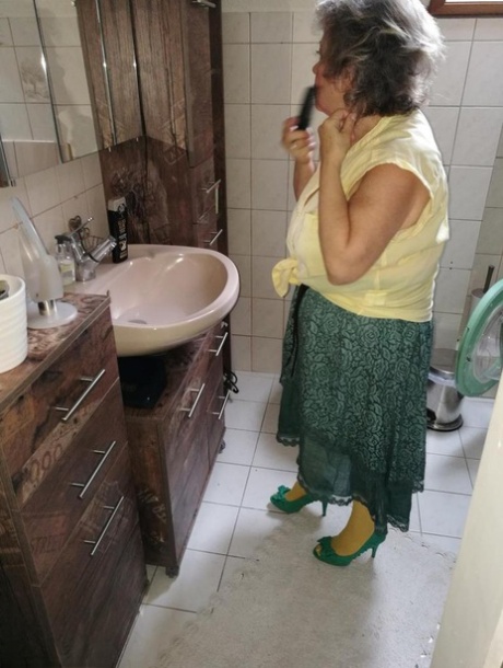 Stará žena Caro uvolňuje svou chlupatou vagínu ze žlutých punčocháčů na posteli