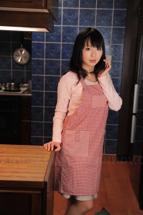 Casalinga giapponese dal bel viso posa non nuda nella sua cucina