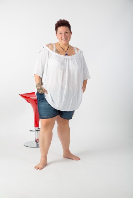 Obese amateur Tattoo Girl sits on a stool after getting totally naked