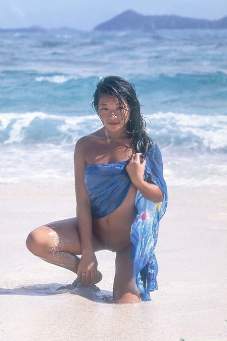 Asijská kráska Zana Sun roztahuje svou kundičku, zatímco je nahá v mořském příboji