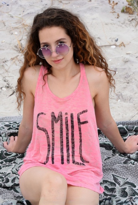 Ładna nastolatka Melissa Maz ma falowane włosy podczas rozbierania się na piaszczystej ziemi
