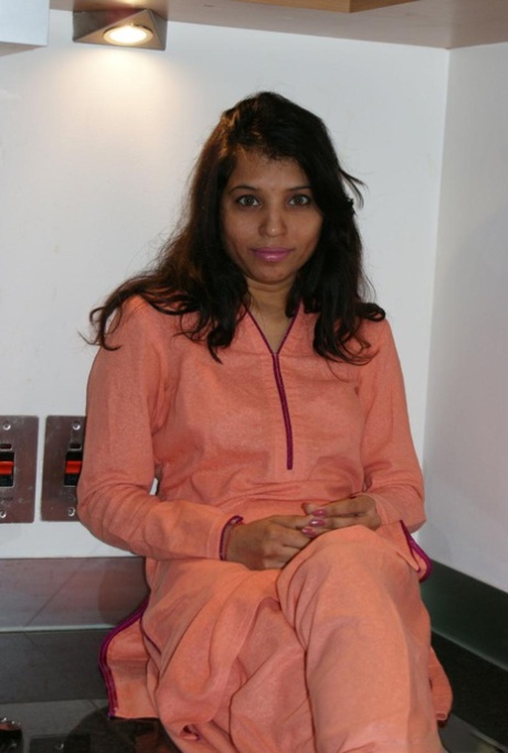 Menina indiana solitária descasca o fato de guerra e a lingerie para se despir na cozinha
