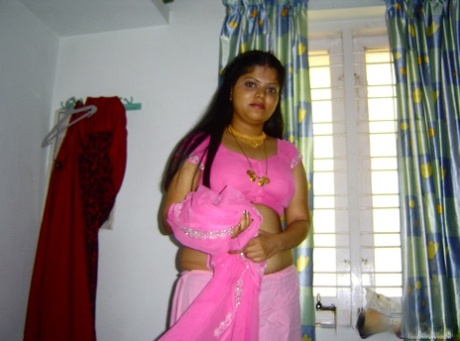 Den fylliga indiska flickan Neha är helt naken på sin säng i en solokampanj