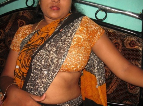 Mature Indian housewife sticks out her tongue while unveiling her natural tits