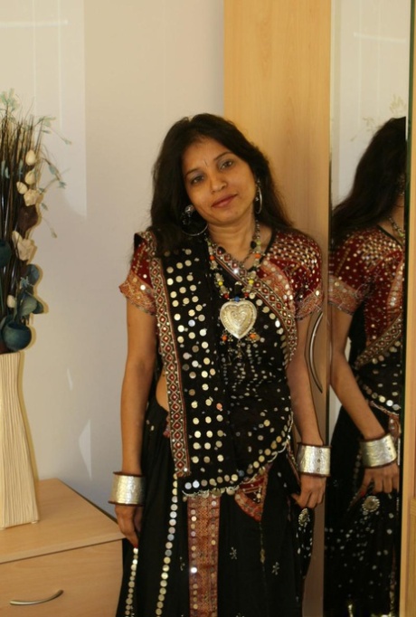 Den indiske MILF-en Kavya Sharma kvitter seg med tradisjonelle klær for å kle seg naken.