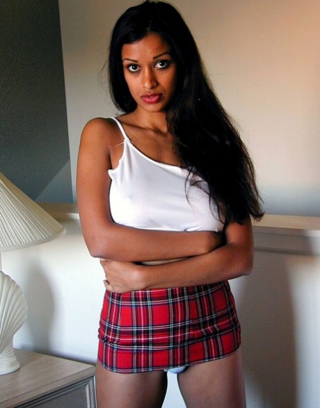 Krásná indická dívka vystavuje svá kulatá prsa a bavlněné kalhotky na posteli