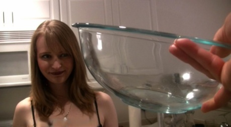 白人の少女がガラスのボウルに小便をした後、中身を飲み込む。