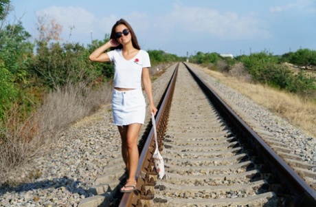 Szczupła nastolatka Baby Shine rozbiera się w klapkach na torach kolejowych
