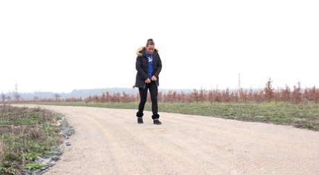 Fully clothed girl Naomi Bennet pulls down her pants to piss on a dirt road