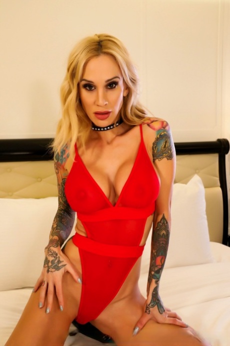 Tattooed blonde Sarah Jessie releases her big tits from bodysuit on bed