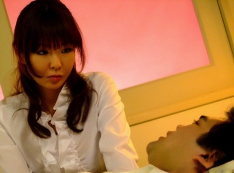 Hübsches japanisches Mädchen gibt ein paar Männern Oralsex in einer weißen Bluse