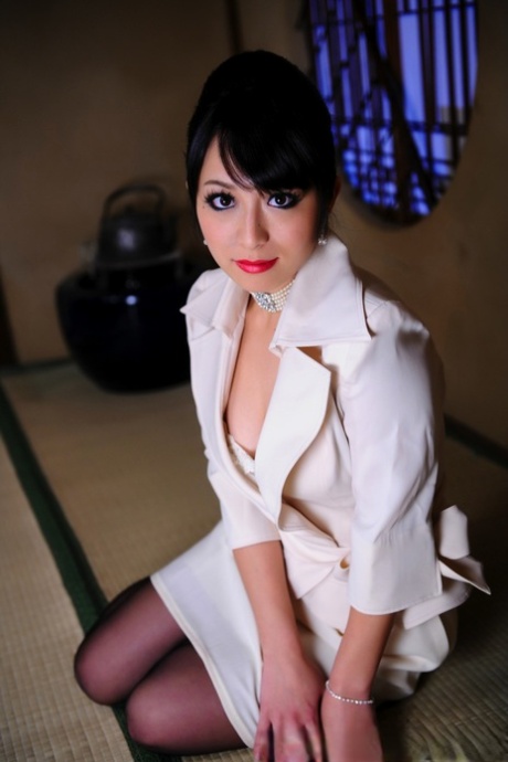 Japonská modelka vystavuje svou špičkovou podprsenku v obchodním obleku a červených rtech