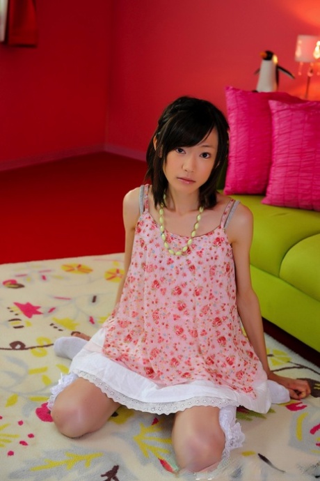 Миниатюрная японская девушка с красивым лицом моделирует обнаженную фигуру в носках до колен