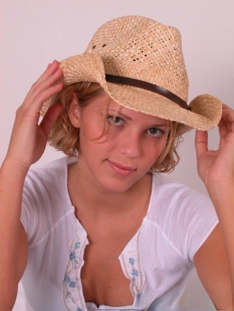 Young blonde Karen covers up her naked breasts with a straw hat in SFW action