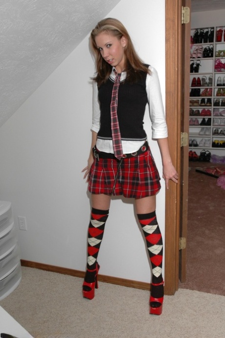Un modèle amateur montre sa jolie culotte dans des chaussettes OTK à carreaux et des talons rouges.