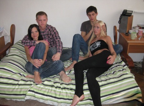 Two young couples swap partners while having foursome sex on a bed