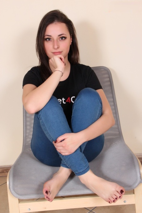 Brunette solomeisje Ilaria toont haar blote voeten tijdens het modellenwerk in jeans