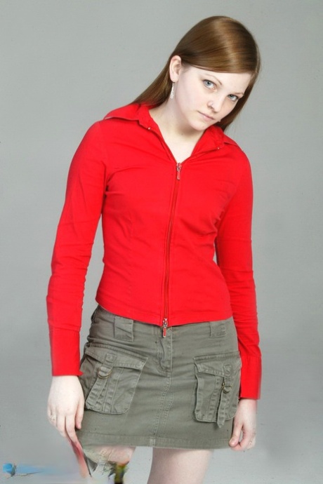 色白の赤毛のLillyがゆっくりと黒のGストリングと赤いレザーブーツを身に着けていく。