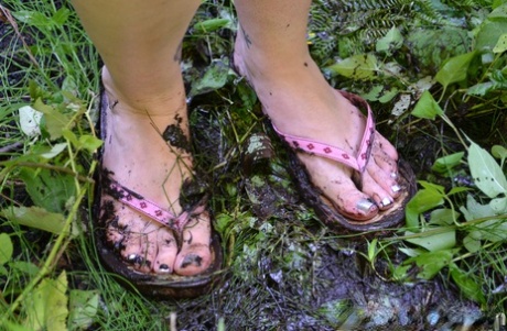 Amateur Hannah Belmont sports muddy feet while fingering her twat under a tree