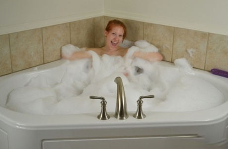 Natural redhead with big boobs dildos her snatch while taking a bubble bath