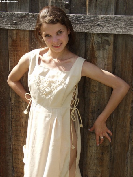 Den brune tenåringen viser frem den stramme rumpa i en lang kjole før hun åpner fitta.