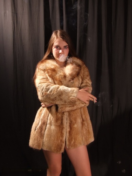 Amateur model smokes while removing fur coat for nude poses