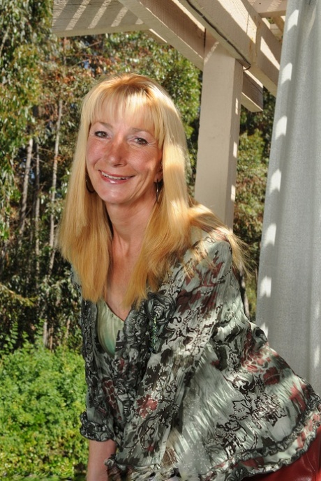 Une dame âgée pose son corps maigre et nu sur un banc dans le jardin.