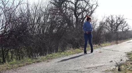 Antonia Sainz, rousse naturelle, fait pipi sur une route à la campagne.