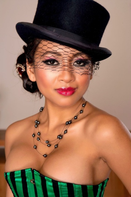 Le modèle asiatique Kina Kai enlève son corset en portant un chapeau haut de forme et des bas nylon.