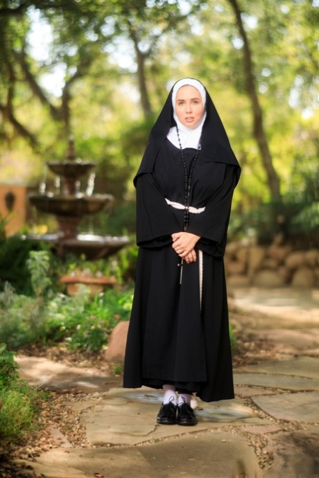 Tyk nonne blotter sig i gården iført overknee-strømper